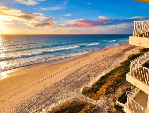 an aerial view of the beach at sunset at Absolute Beachfront Ocean Balcony Heated Pool in Gold Coast