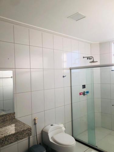 a bathroom with a toilet and a glass shower at Augustos Hotel in Santo Antônio de Jesus