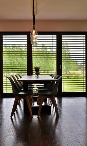 a dining room with a table and chairs and windows at Dom Mazury in Langendorf