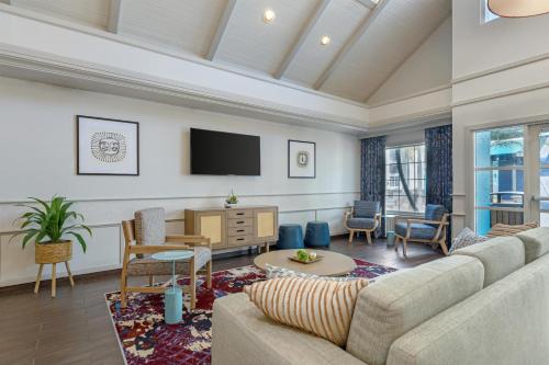a living room with a couch and a tv at Sonesta ES Suites Orlando - Lake Buena Vista in Orlando