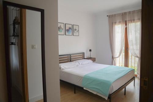 a bedroom with a bed and a large window at CASAMONTl in Sanet y Negrals