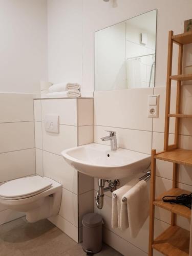 a white bathroom with a sink and a toilet at Gestütsgasthof Marbach in Marbach