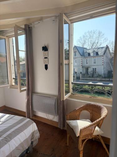 a bedroom with a window with a bed and a chair at Maison bord de sèvre in Coulon