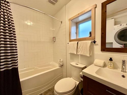 a bathroom with a tub and a toilet and a sink at Le Chalet Waterfront Studio Suite, View, Patio, Kitchen in Ucluelet
