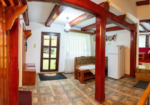a living room with a couch and a refrigerator at Cabana Cremenea in Merişor
