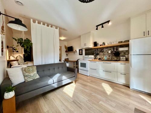a living room with a couch and a kitchen at Le Chalet Waterfront Studio Suite, View, Patio, Kitchen in Ucluelet