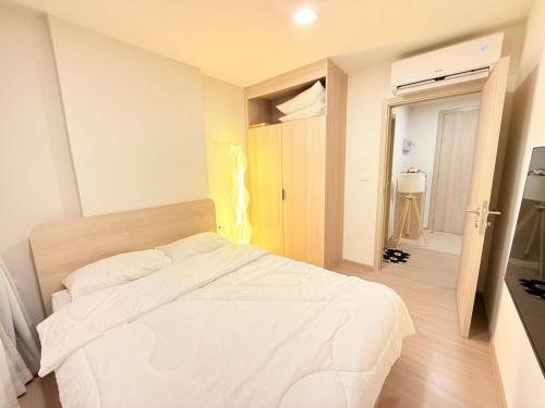 a bedroom with a white bed in a room at Dcondo reef artificial pavement Prime location in Kathu