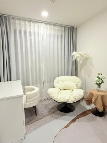 a white room with a white chair and a stool at Dcondo reef artificial pavement Prime location in Kathu