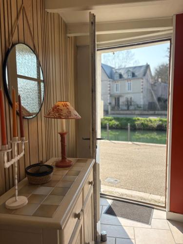 a mirror and a lamp on a counter in a room at Maison bord de sèvre in Coulon