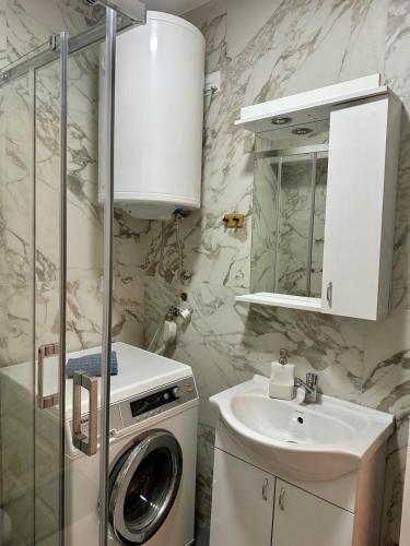 a bathroom with a washing machine and a sink at VIP House 5 in Vrnjačka Banja