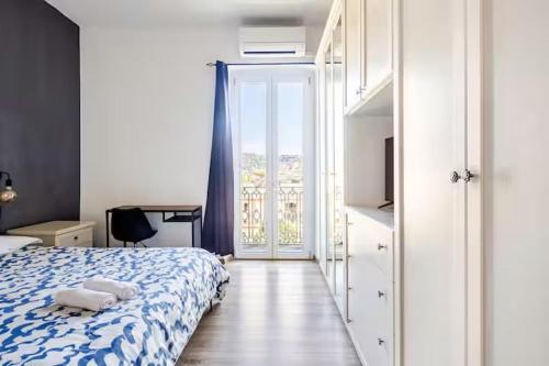 a bedroom with a bed and a sliding glass door at Luminoso Appartamento con Balcone & ParcheggioFree in La Spezia