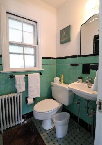 a bathroom with a toilet and a sink and a window at Lofty Elegant Home • Downtown Princeton • 3BR in Princeton