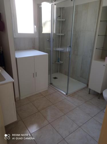 a bathroom with a shower and a tiled floor at villa Montecristo in Cervione