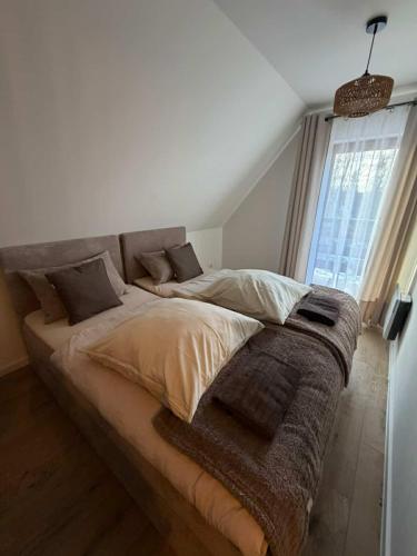 a large bed in a room with a window at Domek u Łowiszów in Dzianisz