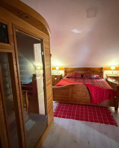 a bedroom with a bed with red sheets and a mirror at KUĆA ZA ODMOR "DVA SRCA" in Čeminac
