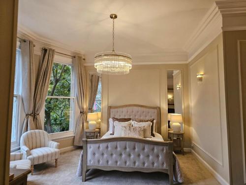 a bedroom with a large bed and a chandelier at Woodland Manor Hotel in Bedford