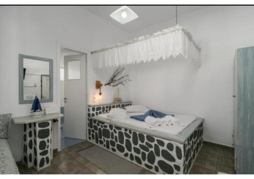 a bedroom with a black and white bed and a mirror at Stella's Mandrakia Seaside House in Mandrakia