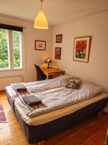 a large bed in a bedroom with a table at Cozy Summerhouse by the River with free BIKES and ping pong in Rovaniemi