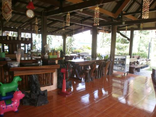 un restaurant avec des tables et des chaises en bois dans une salle dans l'établissement Lanta Together, à Ko Lanta