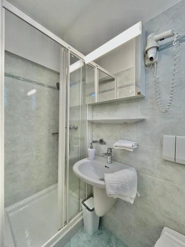 a bathroom with a sink and a shower at Porto MarIn Strašek in Portorož