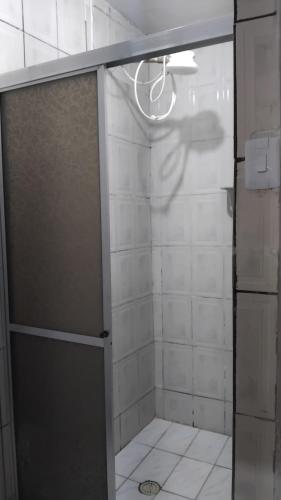 a shower with a glass door in a bathroom at Pousada 3 Bruxas Casa de Hóspedes in São Thomé das Letras