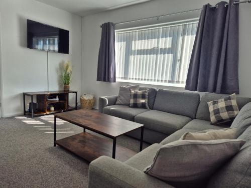 a living room with a couch and a coffee table at Entire House - Cheshire Oaks/Ellesmere Port in Ellesmere Port