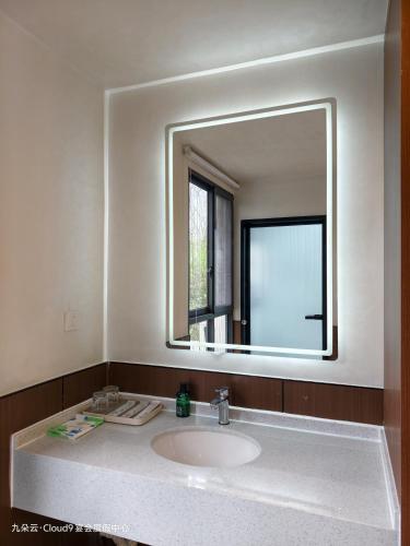 a bathroom with a sink and a large mirror at Cloud 9 Resort Hotel in Yangchang