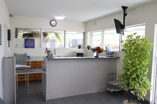 a kitchen with a counter and some windows at Crossroads Inn in Fort Pierce