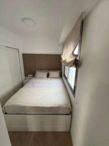 a small bed in a small room with a window at Marina Rey Aparthotel Playa de Puerto Rey in Vera