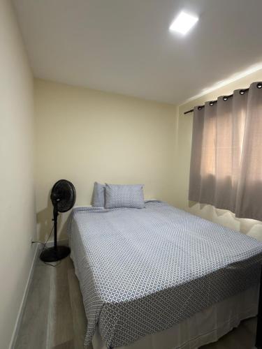 a white bedroom with a bed and a window at Espaço Parque das Gaivotas in Vila Velha