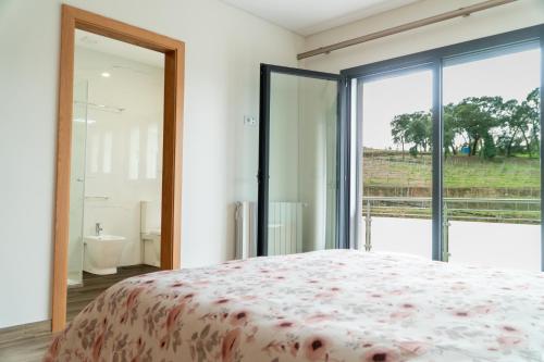 a bedroom with a bed and a large glass window at Casa do Paçô - Cabeceiras de Basto in Cabeceiras de Basto