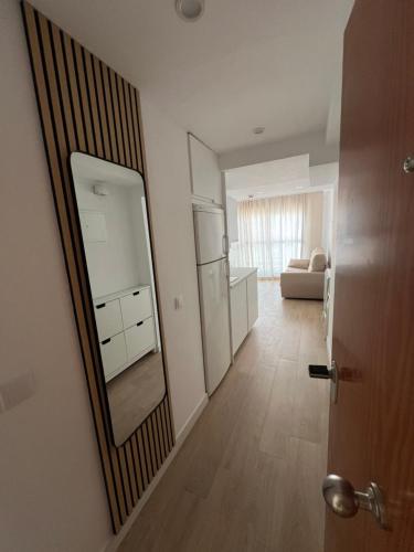 a room with a mirror and a kitchen with a couch at Marina Rey Aparthotel Playa de Puerto Rey in Vera