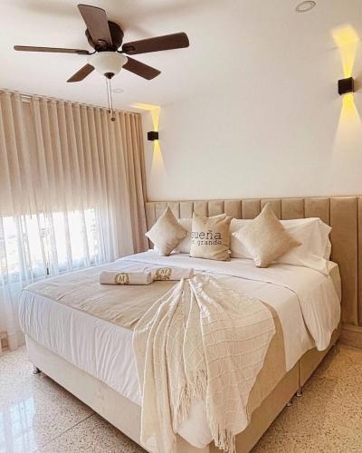a bedroom with a large bed with a ceiling fan at Apartahotel MONACO in Ginebra