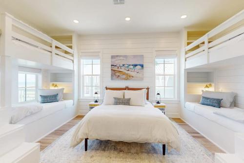 a bedroom with a large bed and two windows at Palmilla Beach Sunrise Dreams in Port Aransas