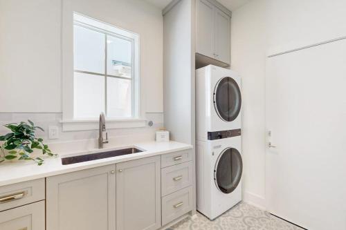 a white kitchen with a sink and a washing machine at Palmilla Beach Sunrise Dreams in Port Aransas