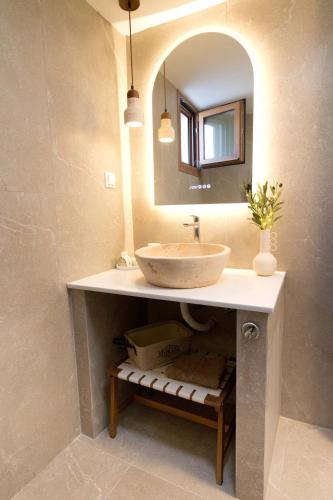 a bathroom with a sink and a mirror at Villa Yvon Telendos - Villa # 1 in Telendos