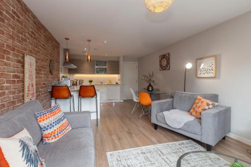 a living room with two couches and a brick wall at Lancaster City Apartment in Lancaster