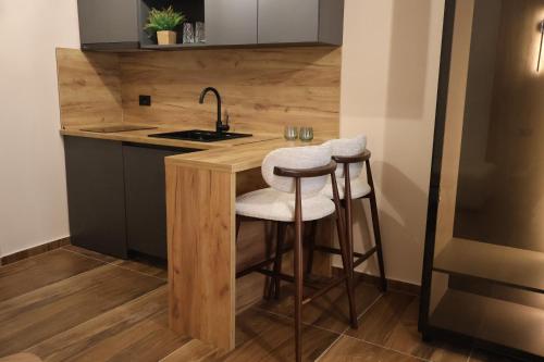 a kitchen with a sink and two bar stools at Hotel and Coffee Bar Old Bazaar in Skopje