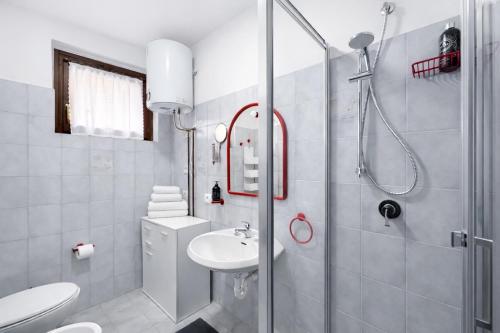 a white bathroom with a shower and a sink at Bella Vita Stays Cozy in Sondrio