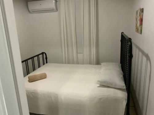 a small bedroom with a bed with a pillow on it at Cozy 2BR Cabin for 5 with Pool in Cabo Rojo