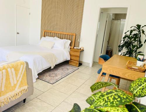 a bedroom with a bed and a table and plants at Downtown Studio Free Parking 1 mi to Beach & Convention Center in Long Beach