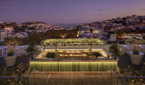 a rooftop garden with a pergola with lights at Tivoli Avenida Liberdade Lisboa – A Leading Hotel of the World in Lisbon