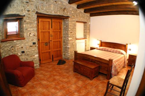 a bedroom with a bed and a stone wall at Il Baglio di Nonna Clelia in Polizzi Generosa