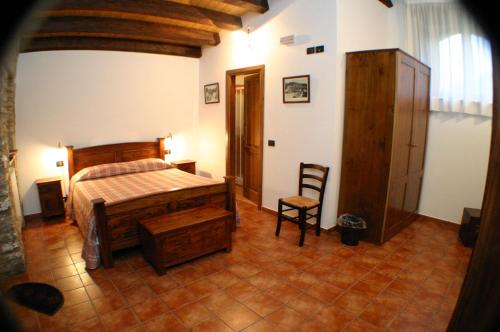 a bedroom with a bed and a chair in a room at Il Baglio di Nonna Clelia in Polizzi Generosa