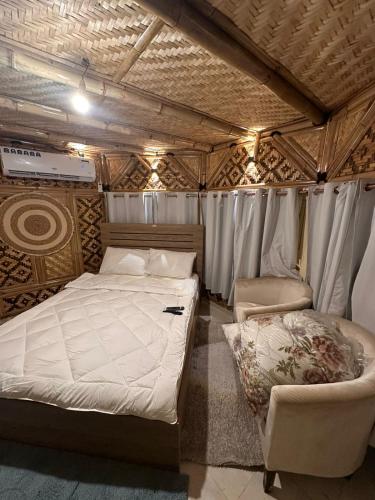 a bedroom with a bed and a chair in a tent at luule in Al Ain