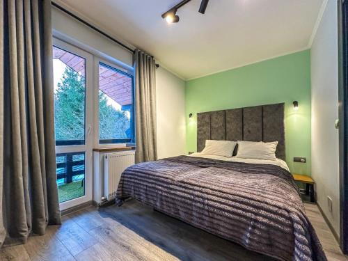 a bedroom with a bed and a large window at Шале in Krivopolʼye