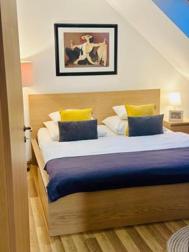 a bedroom with a large bed with yellow and blue pillows at Studio apartman in Kőszeg