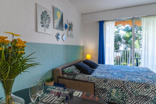 a bedroom with a bed and a window and a table at Super Menton Bord Mer in Menton