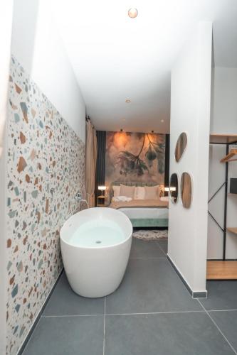 a bathroom with a bath tub and a bedroom at Noah Gate Hotel & Suites in Naples