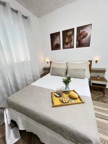 a bedroom with a bed with a tray of food on it at Casa centro de Peruíbe in Peruíbe